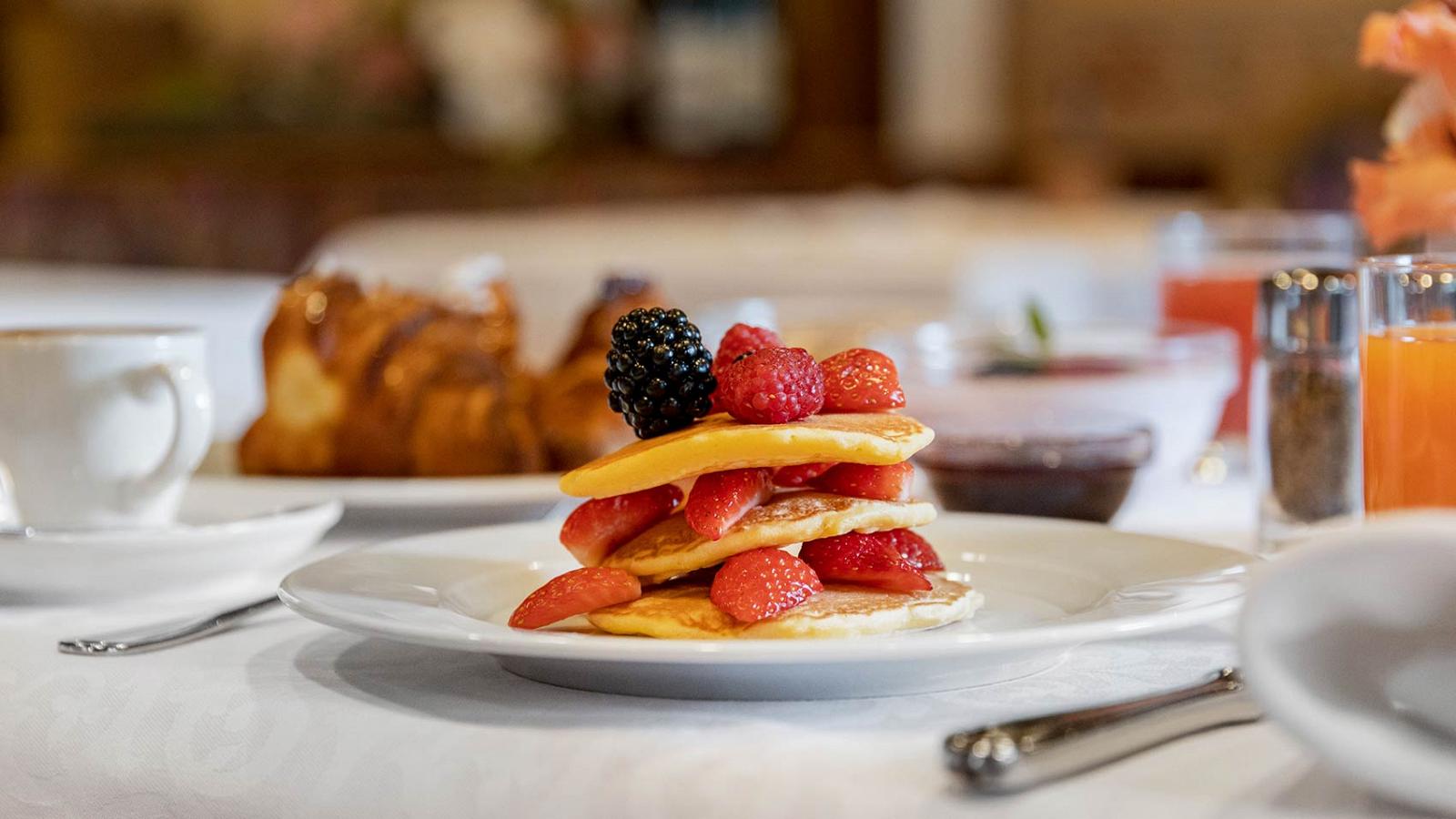 A plate of pancakes with blackberries and strawberries made at the Hotel La Serenella