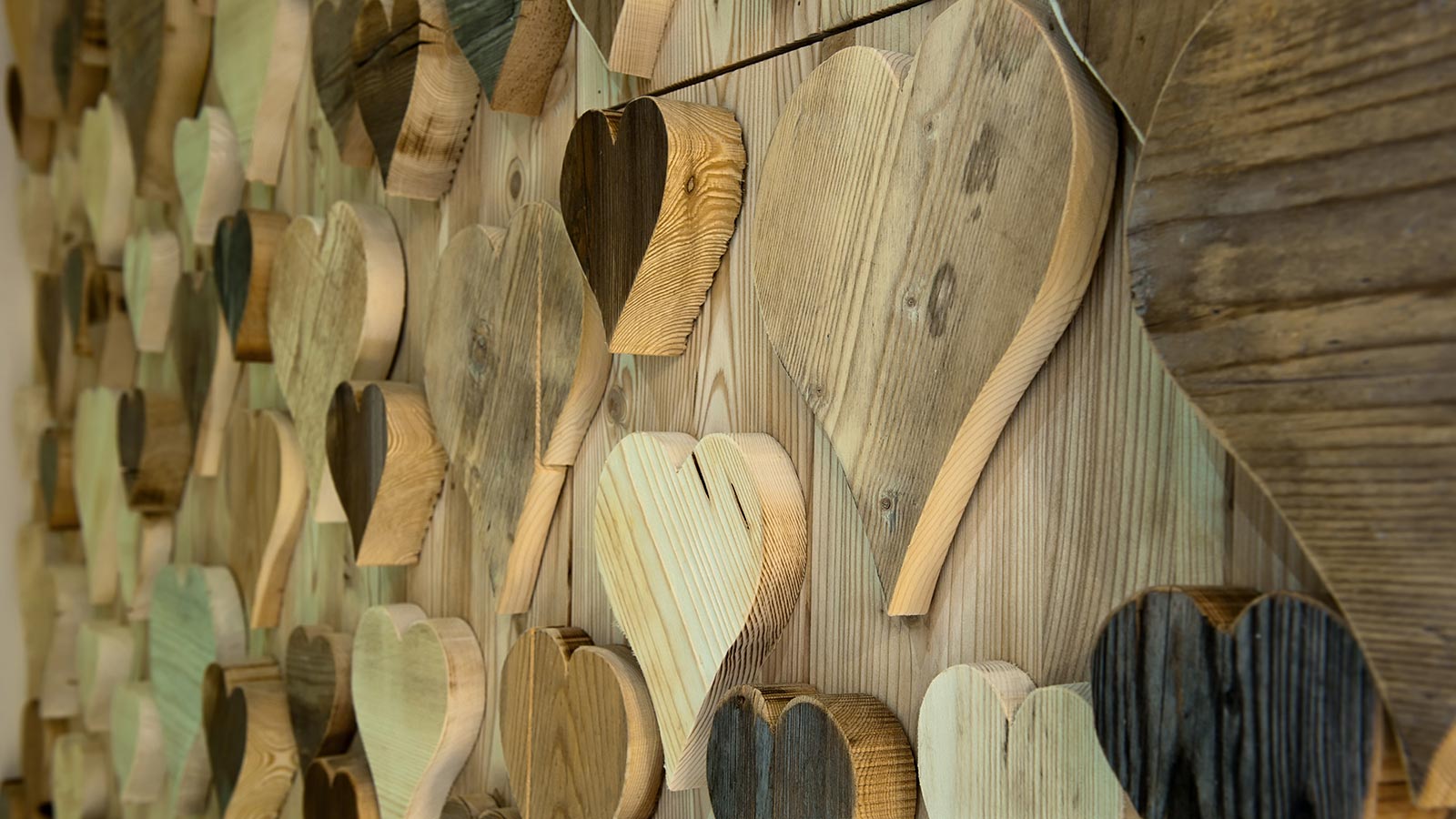 wooden hearts hanging on a wall at La Serenella
